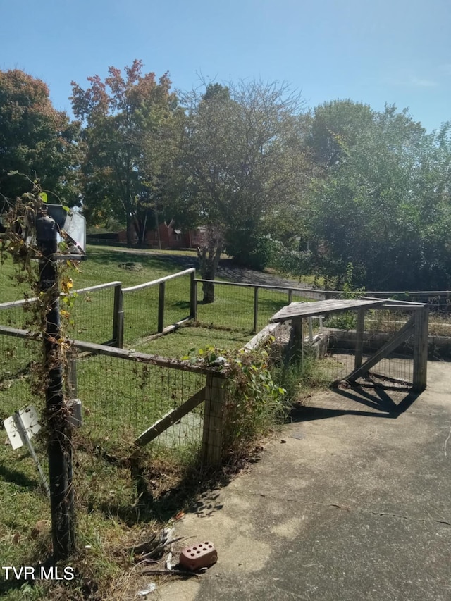 view of gate with a rural view and a yard