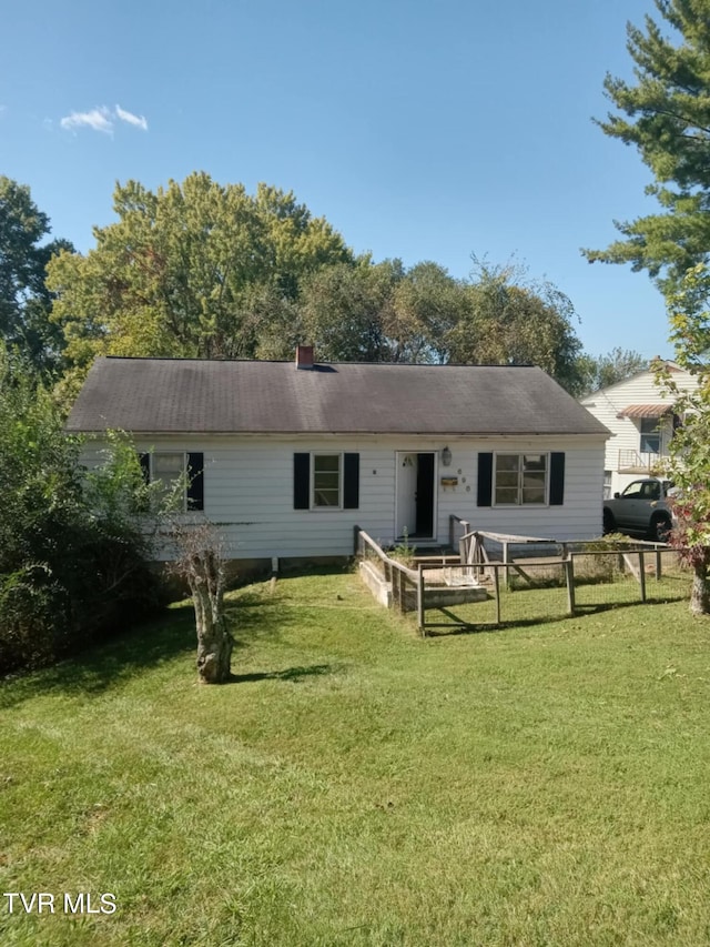 rear view of property featuring a lawn