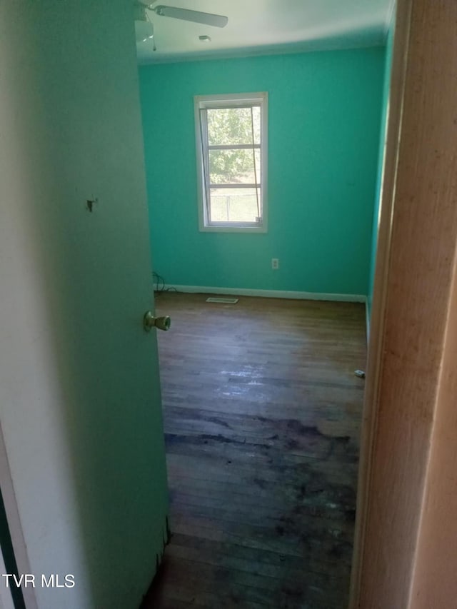 spare room with ceiling fan and dark wood-type flooring