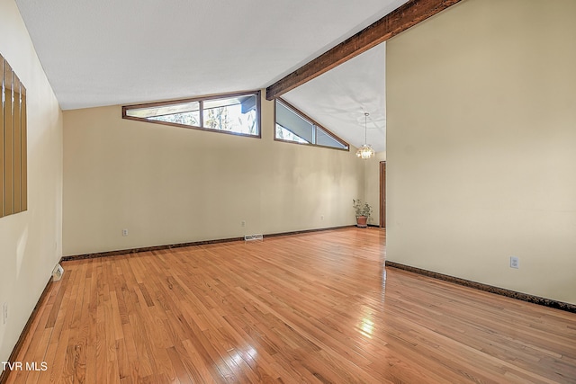 empty room with light wood-type flooring, vaulted ceiling with beams, and an inviting chandelier