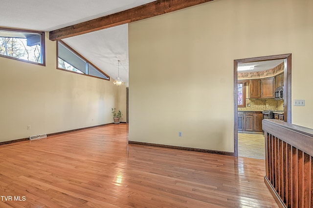 unfurnished room with beam ceiling, an inviting chandelier, high vaulted ceiling, and light wood-type flooring