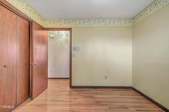 unfurnished bedroom with a textured ceiling and light hardwood / wood-style flooring