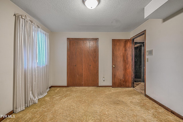 unfurnished bedroom featuring light colored carpet and a textured ceiling