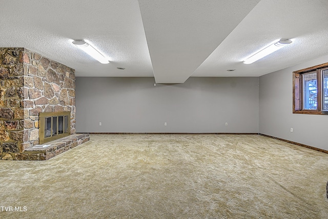 unfurnished living room with carpet flooring, a stone fireplace, and a textured ceiling