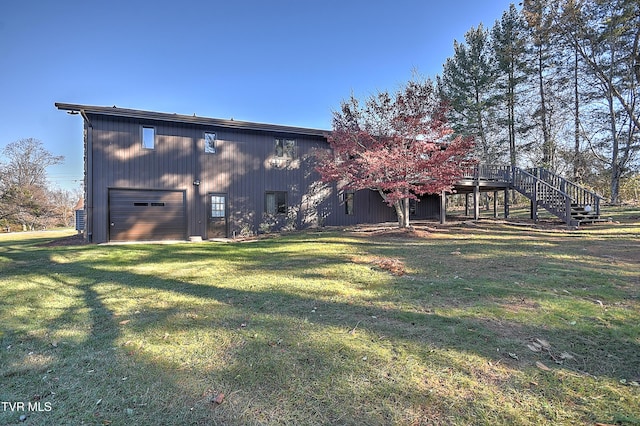 back of house featuring a lawn, a garage, and a wooden deck