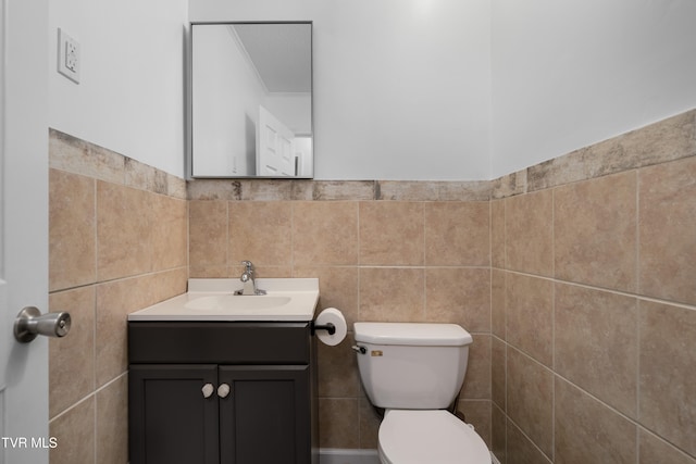 bathroom featuring tile walls, vanity, and toilet