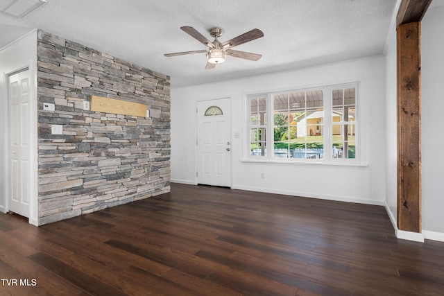 foyer entrance with dark wood-type flooring, a textured ceiling, and ceiling fan