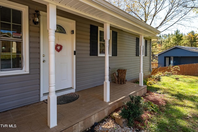 property entrance with a yard and covered porch