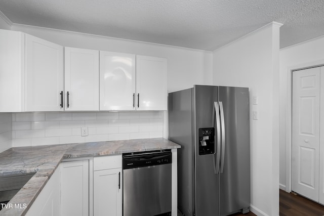 kitchen with dark wood-type flooring, stainless steel appliances, light stone countertops, and white cabinets