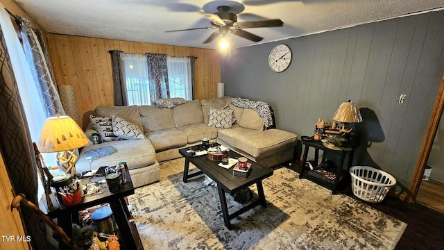 living room with wood walls, hardwood / wood-style flooring, a textured ceiling, and ceiling fan