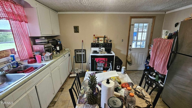 kitchen with white cabinets, ornamental molding, light tile patterned floors, stainless steel refrigerator, and electric range