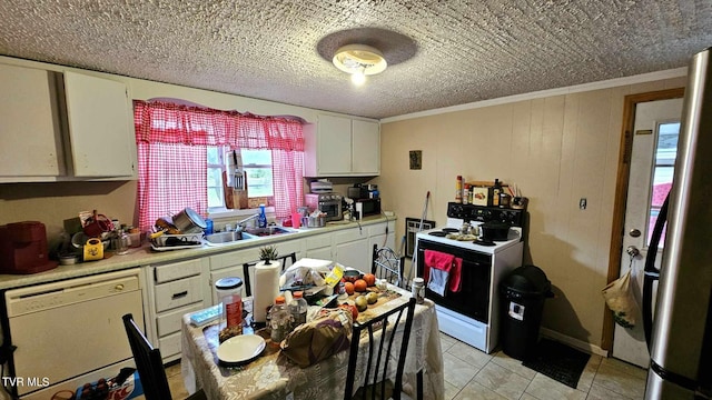 kitchen featuring light tile patterned floors, sink, ornamental molding, white appliances, and white cabinetry