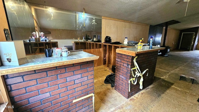 interior space with a textured ceiling and wooden walls