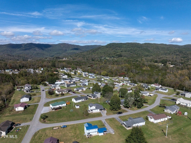 drone / aerial view featuring a wooded view, a mountain view, and a residential view
