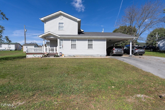 traditional-style house with crawl space, driveway, a front yard, and an attached carport