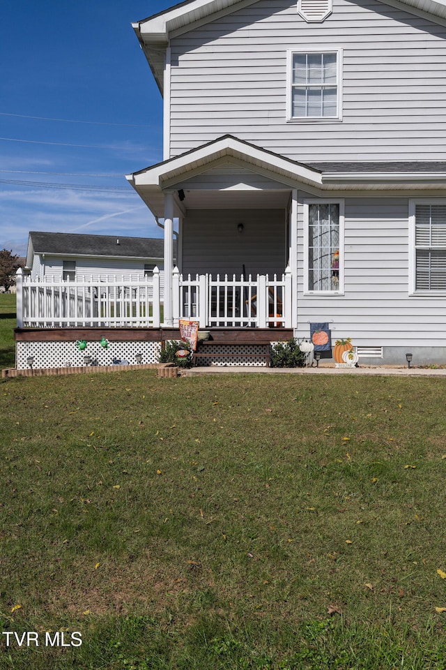 back of property featuring a deck and a yard