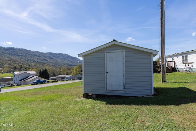 view of outbuilding featuring a lawn and a mountain view