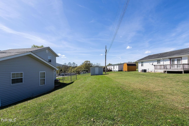 view of yard with a storage shed, cooling unit, a wooden deck, and an outdoor structure