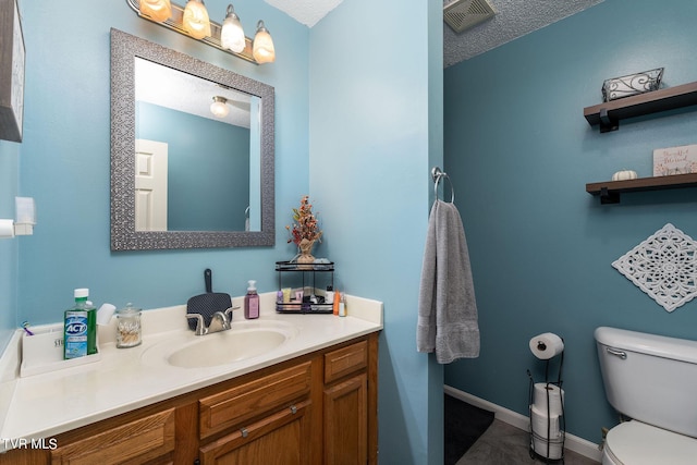 bathroom with visible vents, toilet, vanity, and a textured ceiling