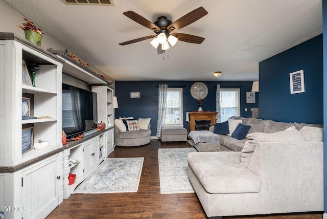 living area with dark wood-style floors and ceiling fan