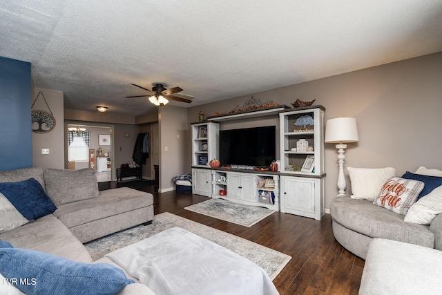 living room with a ceiling fan, a textured ceiling, baseboards, and dark wood-style floors