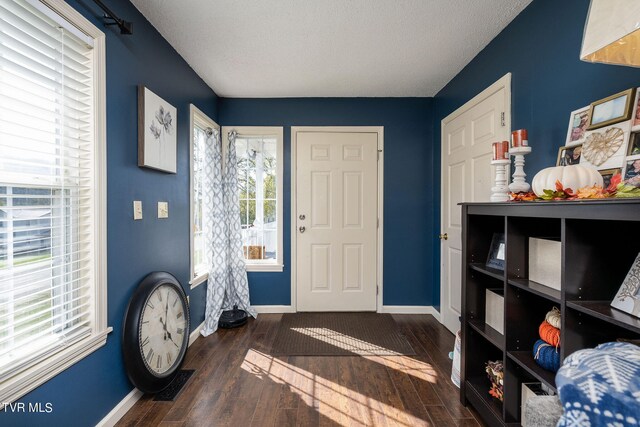 entrance foyer with a textured ceiling and dark wood-type flooring