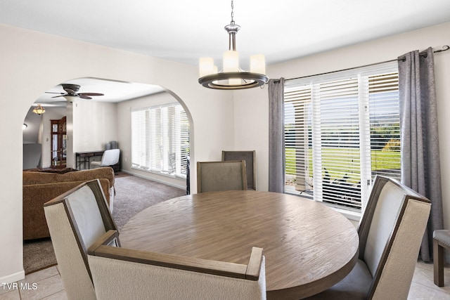 dining area featuring ceiling fan with notable chandelier