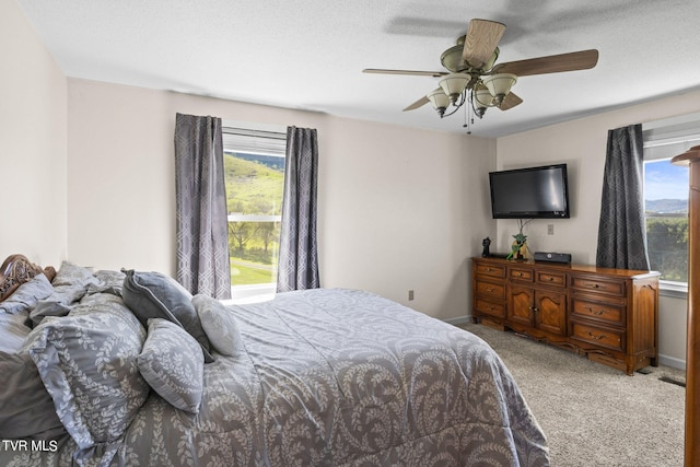 bedroom featuring a textured ceiling, ceiling fan, and carpet flooring