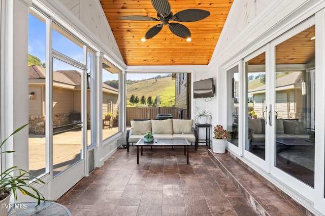 sunroom with ceiling fan, vaulted ceiling, and wood ceiling