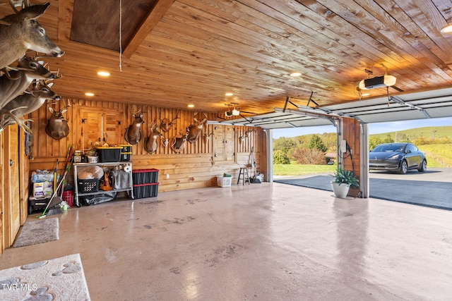 garage featuring a garage door opener, wood walls, and wooden ceiling