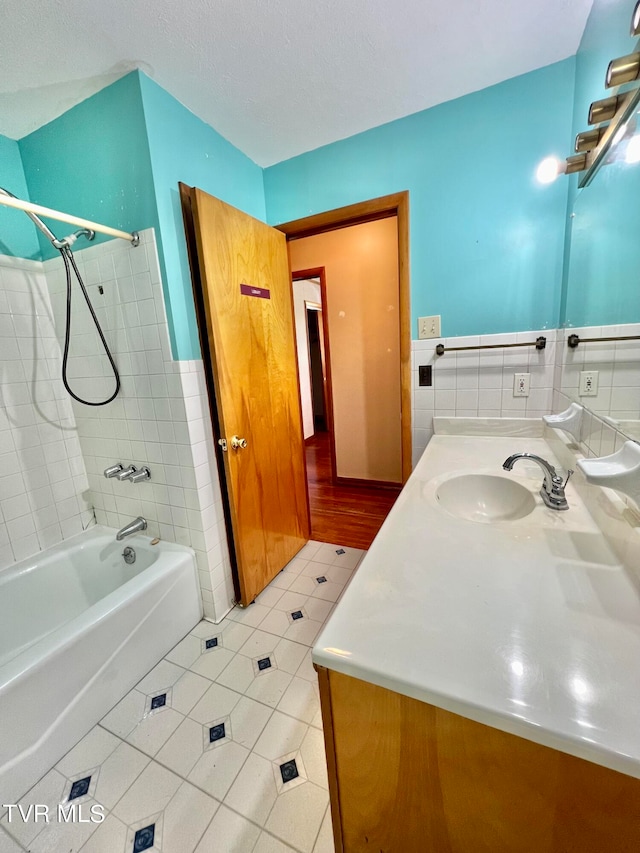 bathroom with vanity, tile patterned flooring, and tiled shower / bath