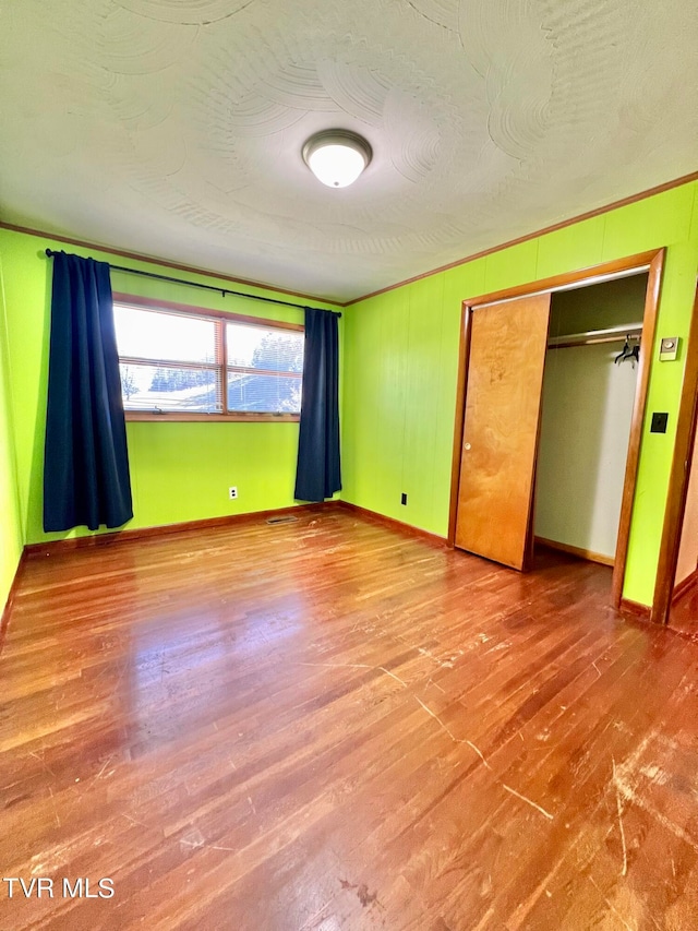 unfurnished bedroom featuring hardwood / wood-style floors and a closet