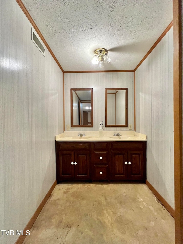 bathroom featuring vanity, crown molding, and a textured ceiling