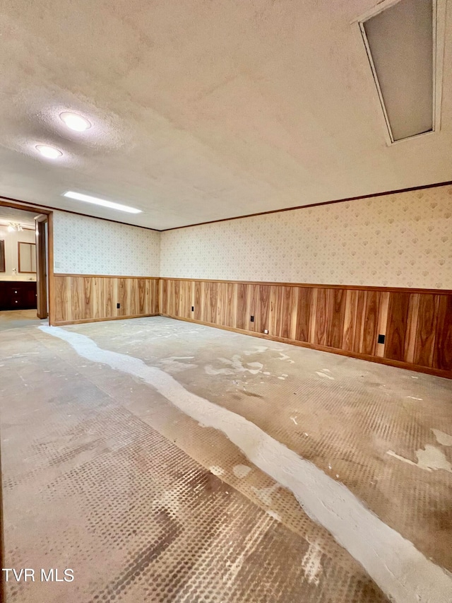 interior space with wooden walls and a textured ceiling