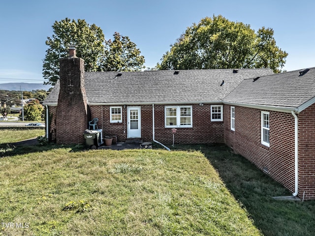 1021 Tusculum Blvd, Greeneville, TN 37745 - rear view of house featuring brick siding, a chimney, a shingled roof, and a lawn
