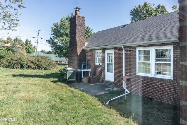 1021 Tusculum Blvd, Greeneville, TN 37745 - back of property featuring a shingled roof, a chimney, brick siding, and a lawn