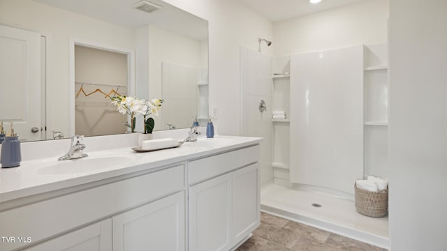 bathroom featuring a shower and vanity