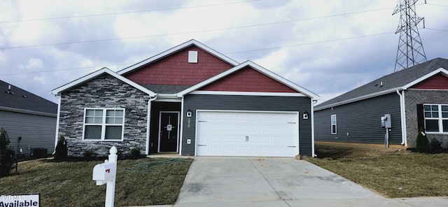 craftsman inspired home with a garage, a front yard, and central AC unit