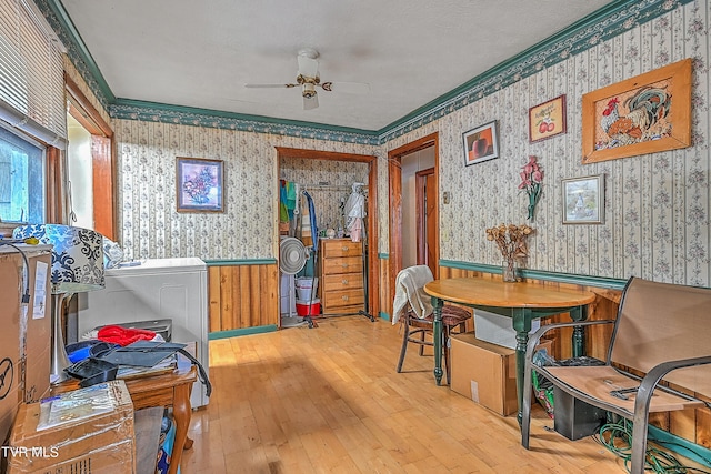 interior space featuring wooden walls, crown molding, light hardwood / wood-style floors, and ceiling fan