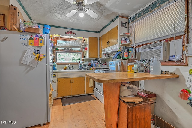 kitchen with light wood-type flooring, refrigerator, a textured ceiling, ceiling fan, and stainless steel electric range oven