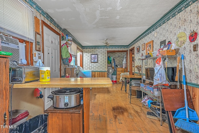 kitchen with crown molding, hardwood / wood-style floors, a textured ceiling, and ceiling fan