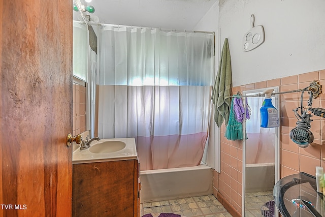 bathroom with vanity, tile walls, and shower / tub combo