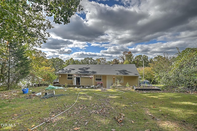 rear view of house featuring a yard