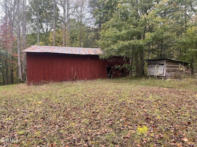 view of outdoor structure featuring a view of trees and an outbuilding