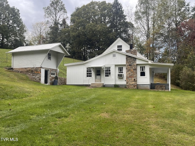 rear view of house featuring a lawn, entry steps, a chimney, and stone siding