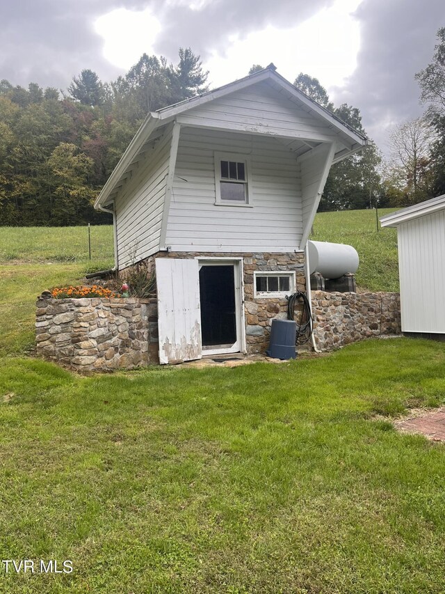 back of house with a lawn, stone siding, and cooling unit