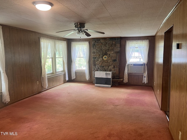 unfurnished living room with carpet flooring, heating unit, and wooden walls