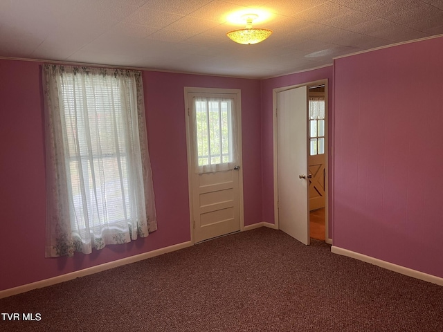 carpeted empty room featuring baseboards