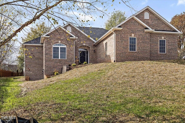 view of front of house featuring brick siding and a front lawn