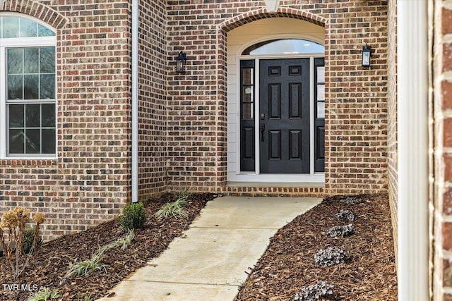 doorway to property with brick siding